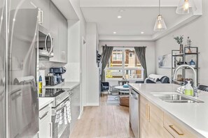 A modern kitchen with a central island, a dining area with a view, and a built-in oven.
