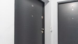 Two dark grey doors with a simple design, a lock, and a keyhole. - Janasa Comfort Studio (Katowice)