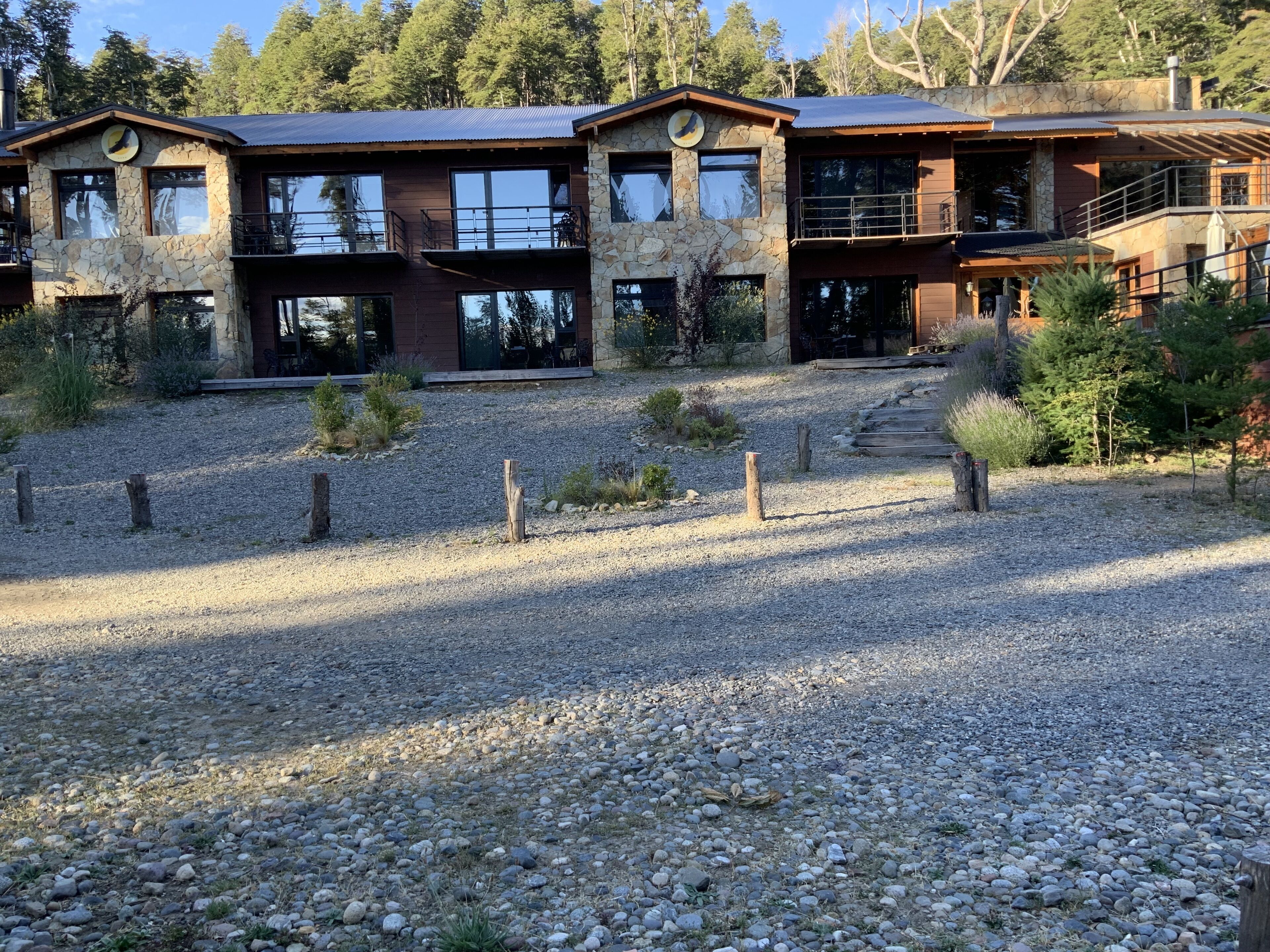 Una casa moderna de dos pisos con fachada de piedra, ventanas amplias y camino de entrada de grava.