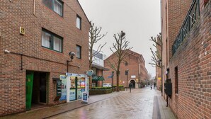 A brick building with a green awning, a visible entrance, and a signboard.