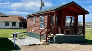A small wooden cabin with a porch and a picnic table labeled B-1. - Cozy cabin in delightful Kemmerer with AC, WiFi (Kemmerer)