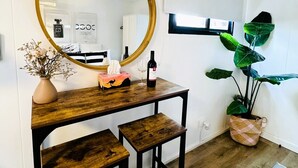 A small, modern bathroom with a wooden vanity, a large mirror, and a potted plant. - Stylish tiny home in Melton west (Melton West)
