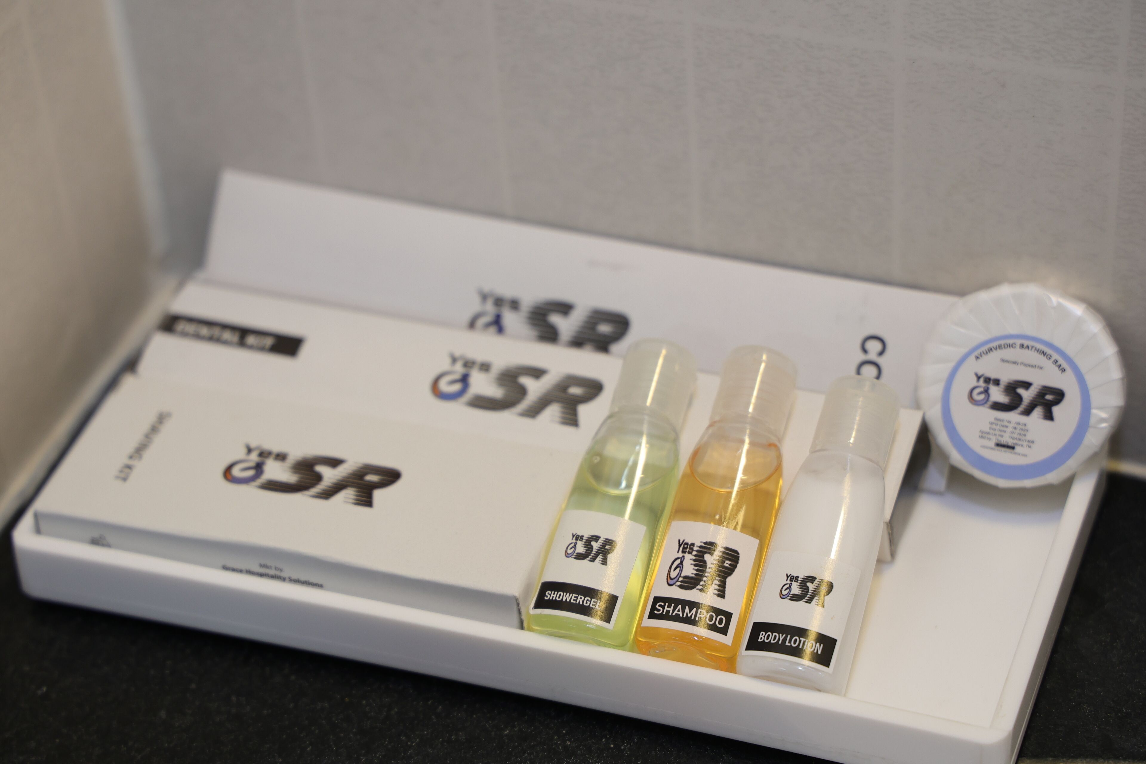 A white tray with a box labeled 'Your GSR' and three bottles labeled 'Shower Gel,' 'Shampoo,' and 'Body Lotion.'