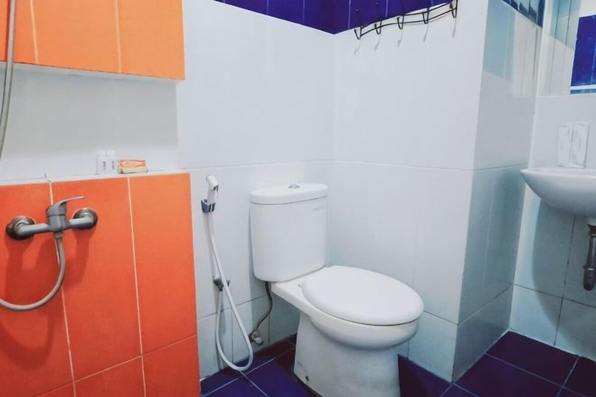Une salle de bain avec des toilettes, une douche et un lavabo.