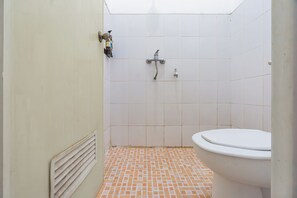 Un baño pequeño con inodoro, ducha y lavamanos.