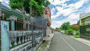 A narrow street lined with buildings, some with balconies and decorative railings. - Hotel O Ita Homestay Syariah (Sidoarjo)