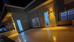 A modern interior with a polished marble floor, large windows, and warm lighting. - 5 Bed Villa Sleeps 10 with Jacuzzi (Georgetown)