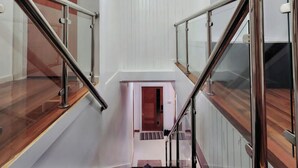 A modern staircase with glass railings and wooden steps. - 5 Bed Villa Sleeps 10 with Jacuzzi (Georgetown)