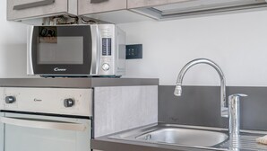 Eine Küche mit Mikrowelle, Edelstahlspüle und einem Doppelbackofen.