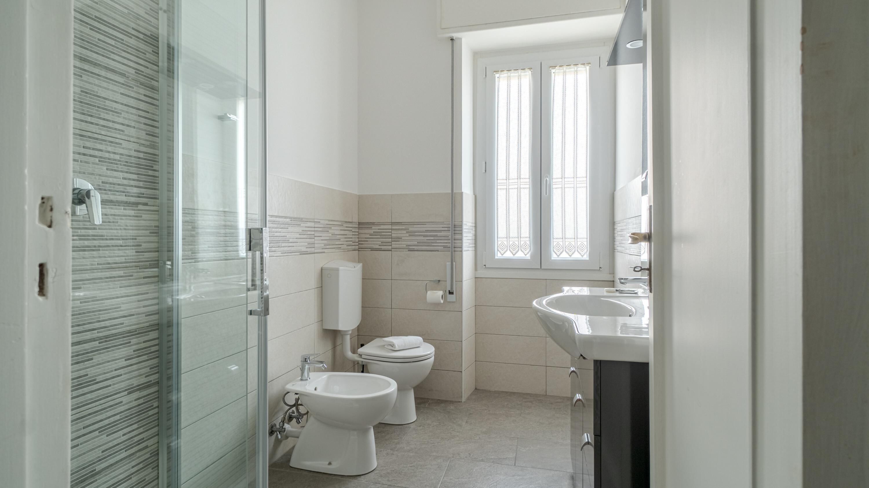 Ein modernes Badezimmer mit einer Glasdusche, einer Toilette und einem Waschbecken.