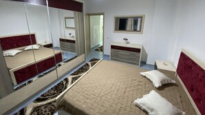 A bedroom with a bed, a dresser, a mirror, and a window. - Beautiful 2-bedroom flat sea view Durres (Durres)