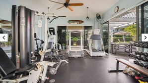 Une salle de sport équipée de machines de cardio, d’appareils de musculation et d’un tapis de course.