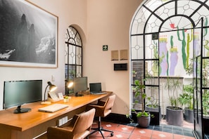 Work in comfort with a desk, computer monitors, and a laptop, plus a view of a cactus garden.