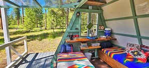 A cabin with a wooden deck, a bunk bed, a desk with a kettle, and a window overlooking a forest. - A-Frame Glamping. Stargazing Near Missoula (Potomac)