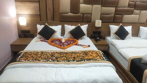A hotel room with two beds, a heart-shaped flower arrangement on the beds, and a wooden headboard. - Poddar Residency (Cooch Behar)