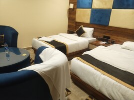 Una habitación de hotel con dos camas, una mesa redonda y una silla.