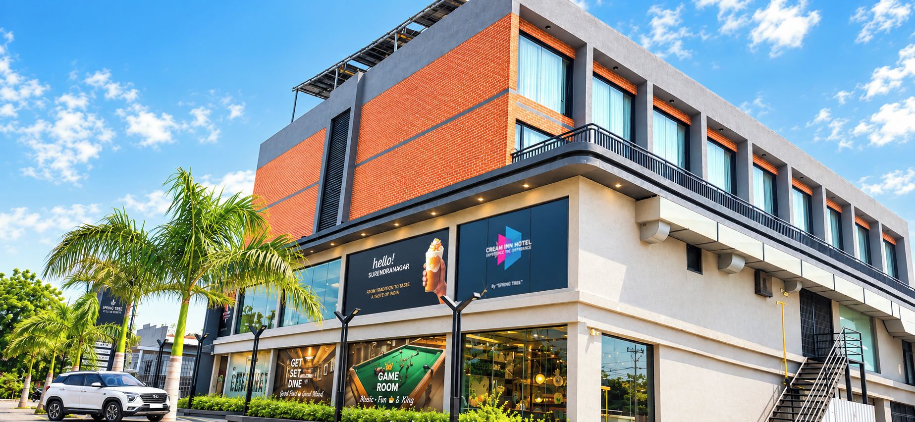 Un hotel moderno con un letrero llamativo que dice 'Cream Inn Hotel' y un anuncio de 'Game Room'.