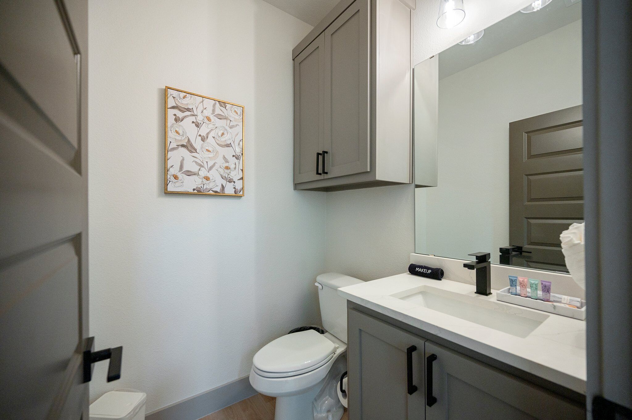 Een moderne badkamer met toilet, wastafel en kast.