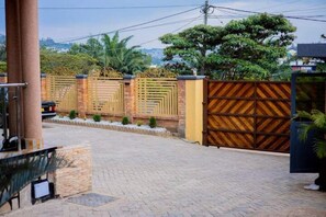 Enter a serene oasis through the beautifully designed entrance, featuring a geometric patterned gate and a brick wall.