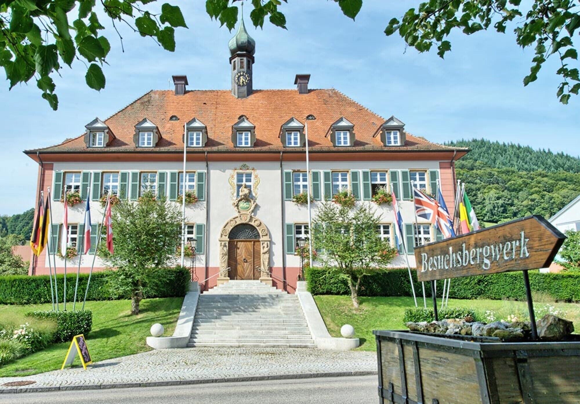 A large building with a central entrance, multiple windows, and a flag display.