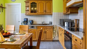 A kitchen with wooden cabinets, a coffee maker, a microwave, and a toaster. - Apartment "Burgblick" with Mountain View, Shared Terrace & Wi-Fi (Plaue)