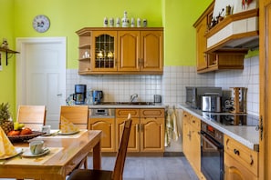 A kitchen with wooden cabinets, a coffee maker, a microwave, and a toaster. - Apartment "Burgblick" with Mountain View, Shared Terrace & Wi-Fi (Plaue)