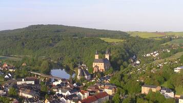 A town with a prominent church, a bridge, and a river.