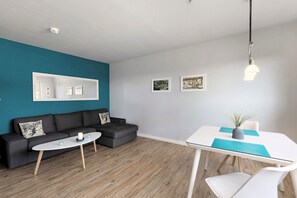 Un salon moderne avec un canapé, une table basse et une table à manger.