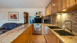 A kitchen with wooden cabinets, a stainless steel refrigerator, an oven, a microwave, a sink, and a countertop. - Studio Apartment 'Haus Am Bächel 2' with Shared Terrace and Wi-Fi (Sasbach)