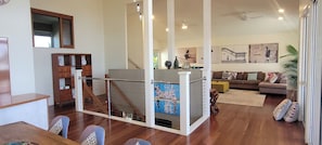A spacious living area with a staircase, a sofa set, and a dining area. - BankSea Holiday Home (Agnes Water)