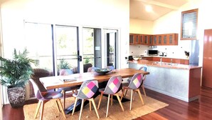 Une cuisine moderne avec des meubles en bois, un îlot central intégré et un réfrigérateur en acier inoxydable.
