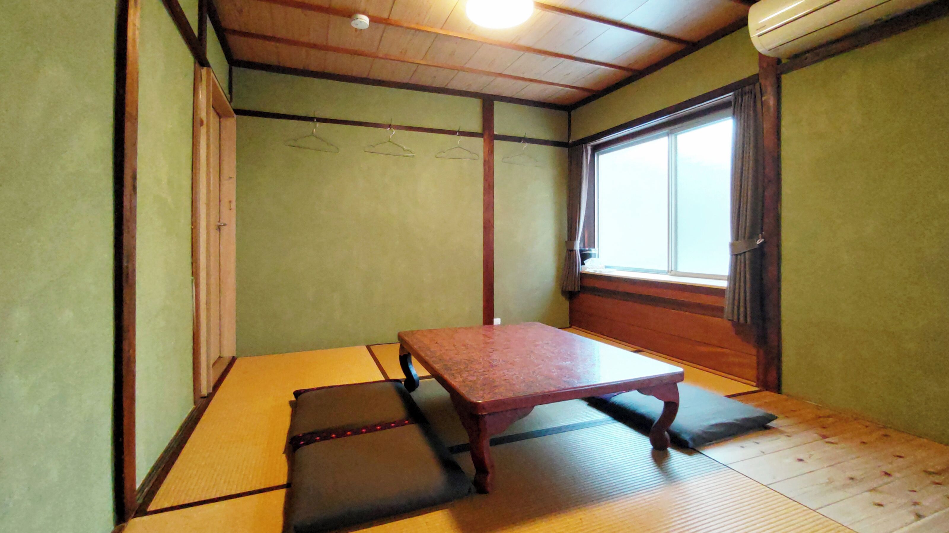 A tatami mat room with a low wooden table and a sliding door.
