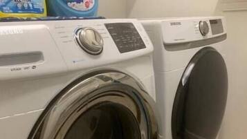 A front-loading washing machine and dryer in a laundry room.