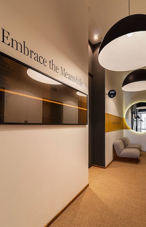 Relax in the hotel lobby, featuring a curved mirror, seating area, and pendant lighting.