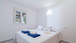 A bedroom with a bed, two pillows, a window, and a bedside table. - Limoncello - Denia, Costa Blanca (Denia)