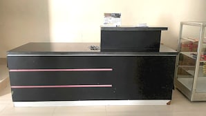 A reception desk with a calendar, drawers, and a glass display case. - Hotel O Setia Budi Guest House 2 (Ngasinan Kulon)