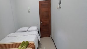 A small, clean room with a bed, a wooden door, and a small rug. - Hotel O Setia Budi Guest House 2 (Ngasinan Kulon)