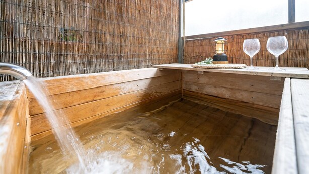A wooden hot tub with a bamboo wall, a water spout, and two wine glasses on a wooden ledge. - Gapyeong Haneuldari pet Pension (Gapyeong)
