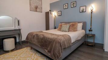 Un dormitorio con cama, lámparas de noche, escritorio y una silla.