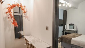 Une chambre à coucher avec un lit, une table de chevet, un miroir et une commode.