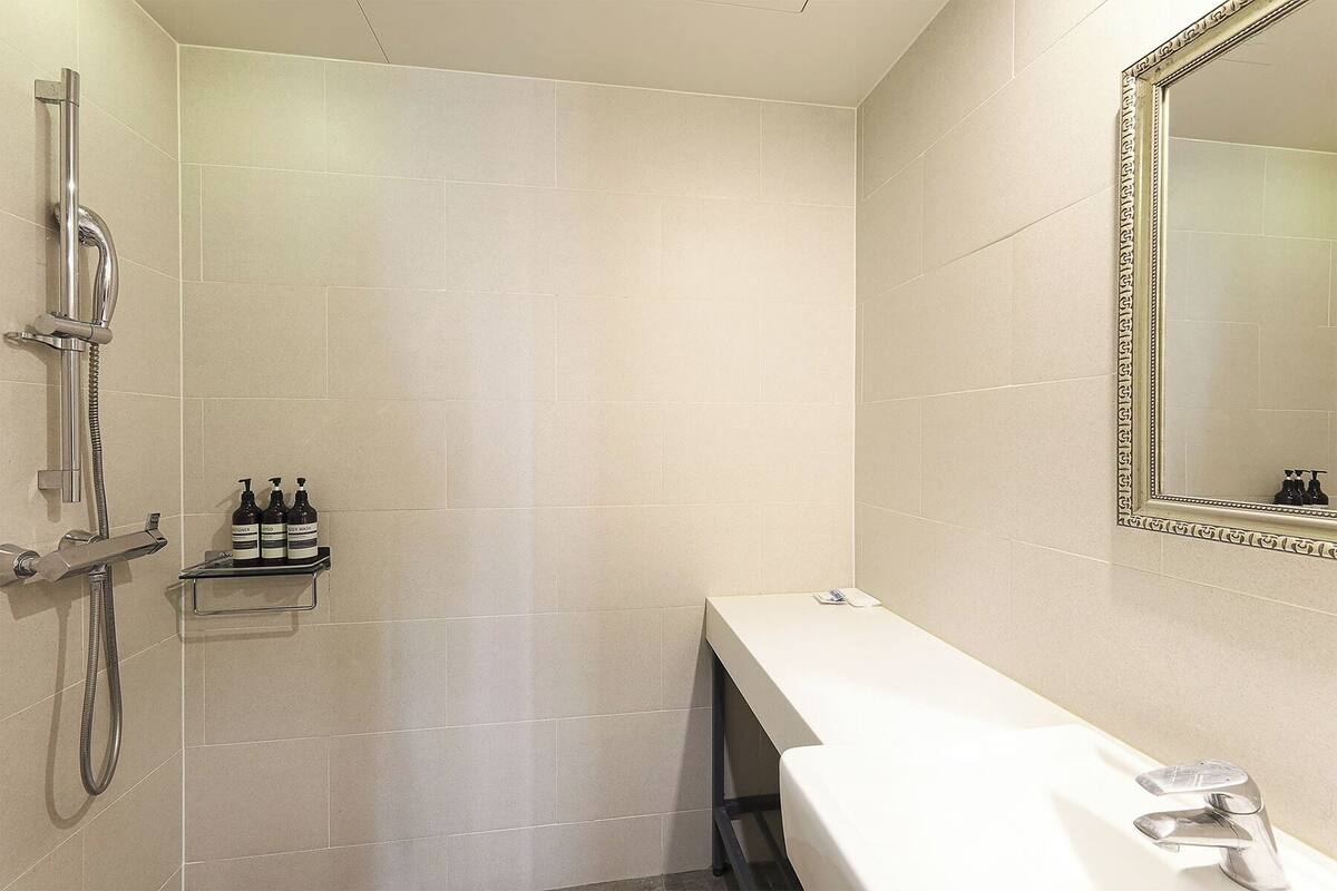 A modern bathroom with a shower, a toilet, and a sink.