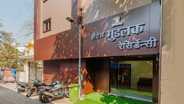 A hotel with a modern facade, a visible entrance, and a sign in a foreign language. - Hotel Good Luck Residency (Mumbai)