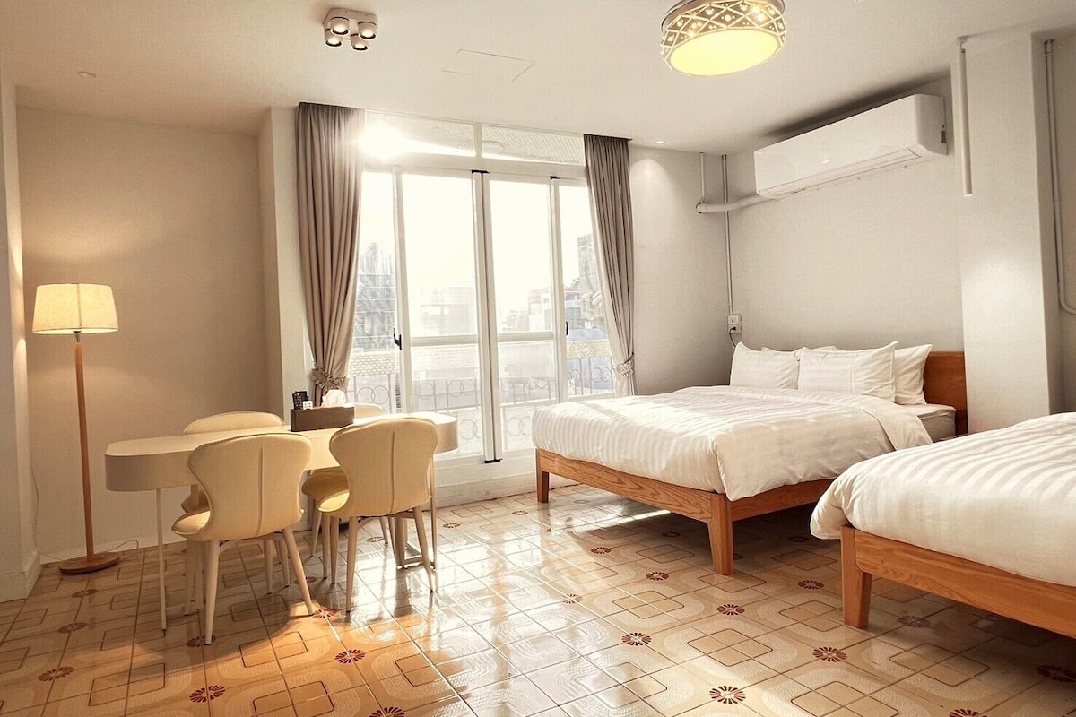 A hotel room with a bed, a desk, and chairs.