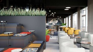 A modern hotel lobby with a reception desk, seating area, and large windows. - Aspire Palais Recklinghausen,Trademark Collection by Wyndham (Recklinghausen)