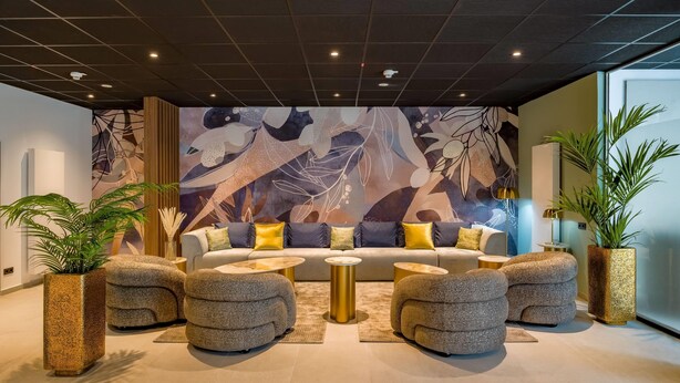 A modern living room with a sofa, round coffee tables, and decorative planters. - Aspire Palais Recklinghausen,Trademark Collection by Wyndham (Recklinghausen)