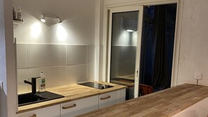 Une cuisine moderne avec un plan de travail en bois, un évier et une fenêtre agrémentée de rideaux.
