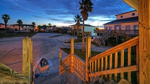 A wooden staircase leading to a building with a view of a sunset. - Private Pool, in Golf Cart Zone, Golf Cart for Rent | Sea Therapy by AvantStay (Port Aransas)