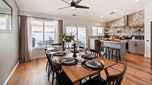 A modern kitchen with a central island, built-in appliances, and a herringbone-patterned backsplash. - Montego by AvantStay | Private Yard w/ Pool & Hot Tub (Indio)