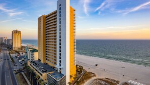 Un hotel moderno de altura con varios balcones que dan a la playa.