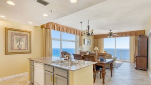 Una cocina con una isla grande, un comedor con vistas y un amplio salón.